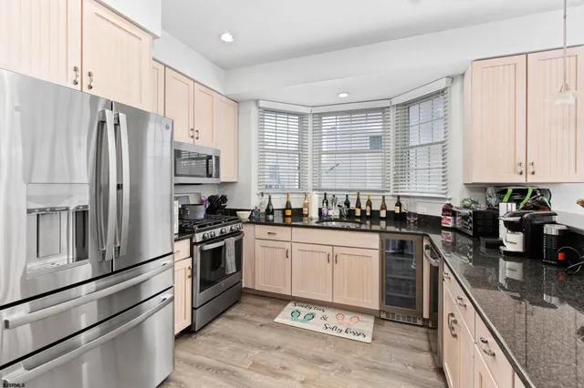 a kitchen with stainless steel appliances granite countertop a stove a sink and a refrigerator