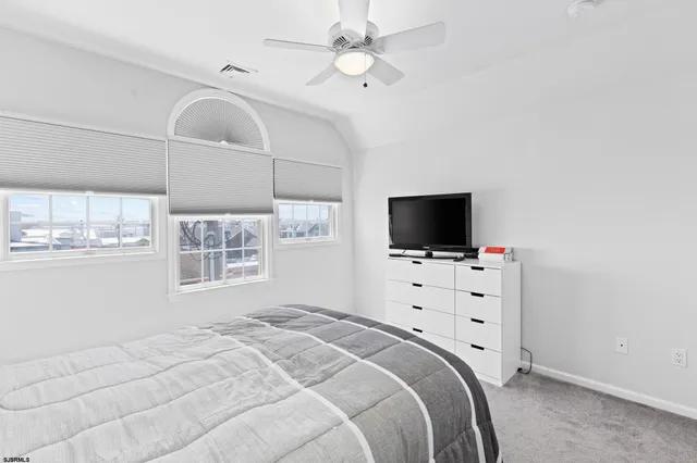 a bedroom with a bed tv and a window