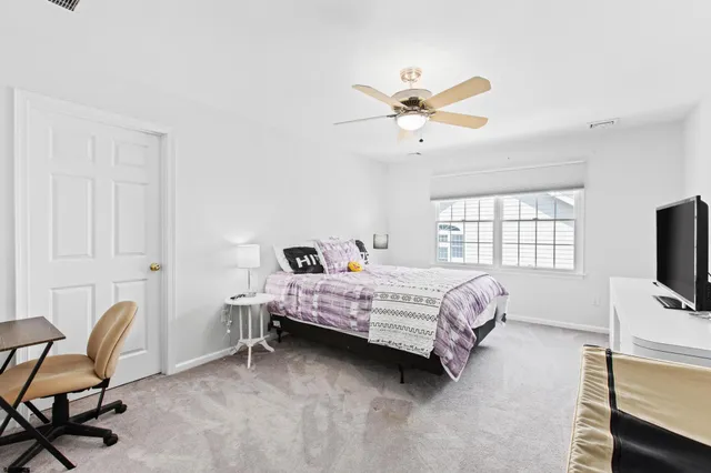 a bedroom with a bed a chair and a chandelier