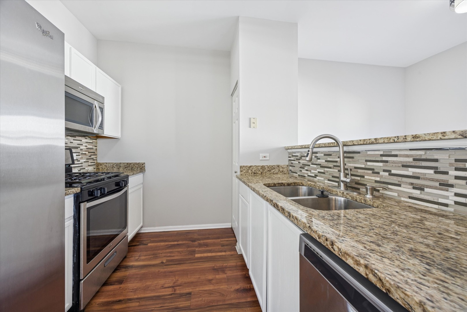 117 Enclave Circle, Unit C Bolingbrook, IL 60440 - Photo 4 of 19 a kitchen with stainless steel appliances granite countertop a sink and stove top oven