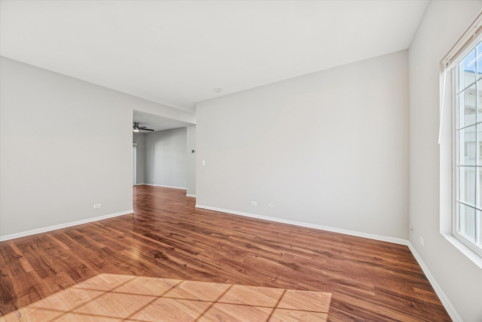 117 Enclave Circle, Unit C Bolingbrook, IL 60440 - Photo 8 of 19 a view of empty room with wooden floor and fan