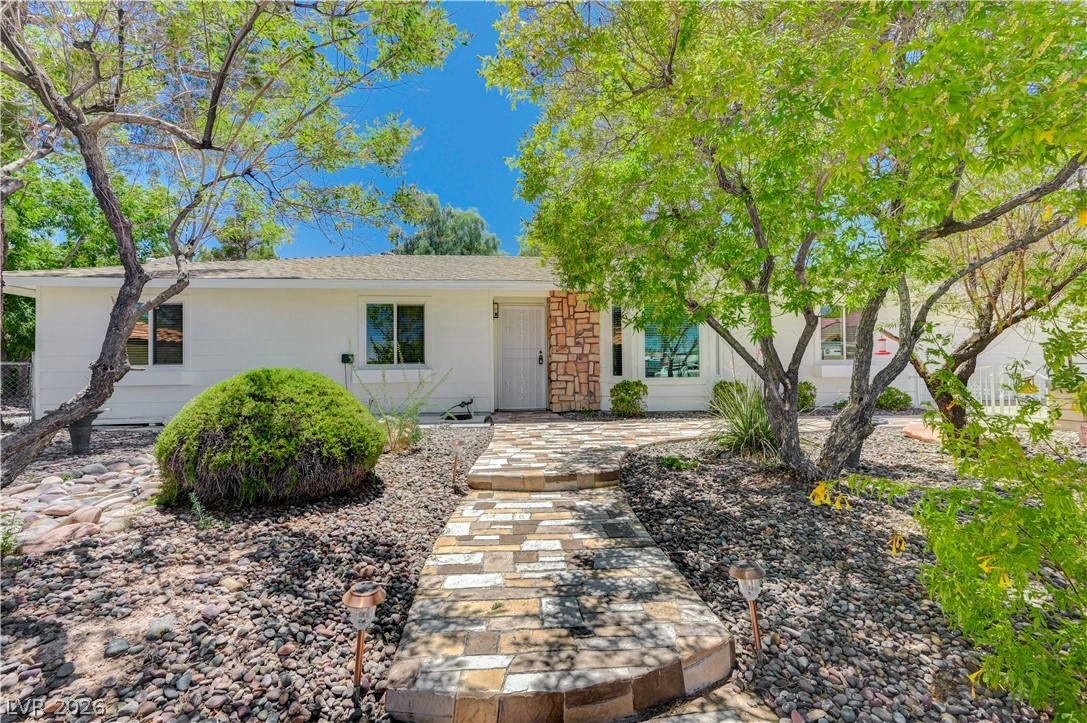 7631 Bermuda Road Las Vegas, NV 89123 - Photo 6 of 64 A welcoming front path leads to a bright home with natural stone accents and lush landscaping.