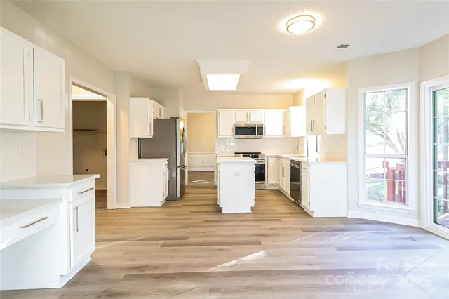 a large kitchen with a large counter top and stainless steel appliances