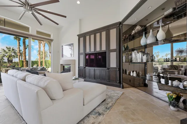 a large bedroom with a bed a couch and large window