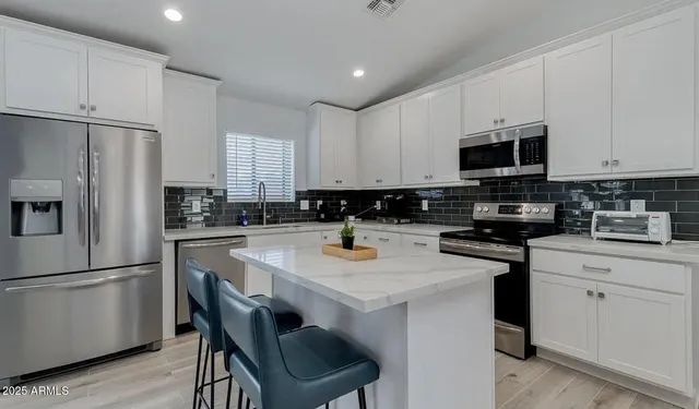 a kitchen with stainless steel appliances a refrigerator stove microwave and cabinets