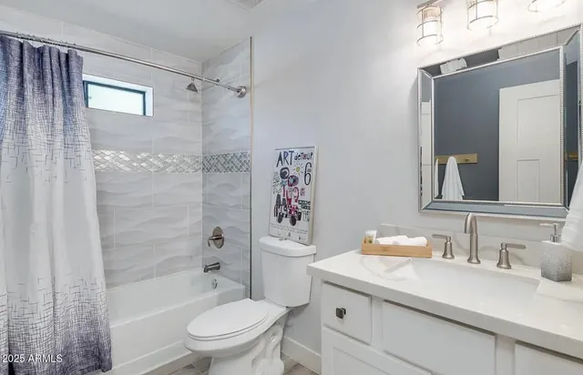 a bathroom with a granite countertop sink a toilet and shower