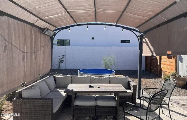a roof deck with table and chairs and potted plants