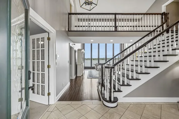 a kitchen with stainless steel appliances kitchen island granite countertop a refrigerator a stove a sink a dining table and chairs with wooden floor