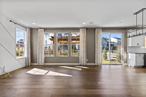 a view of an empty room with window and wooden floor
