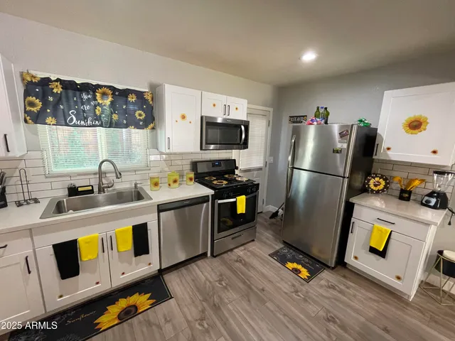 a kitchen with stainless steel appliances a stove a refrigerator and a sink