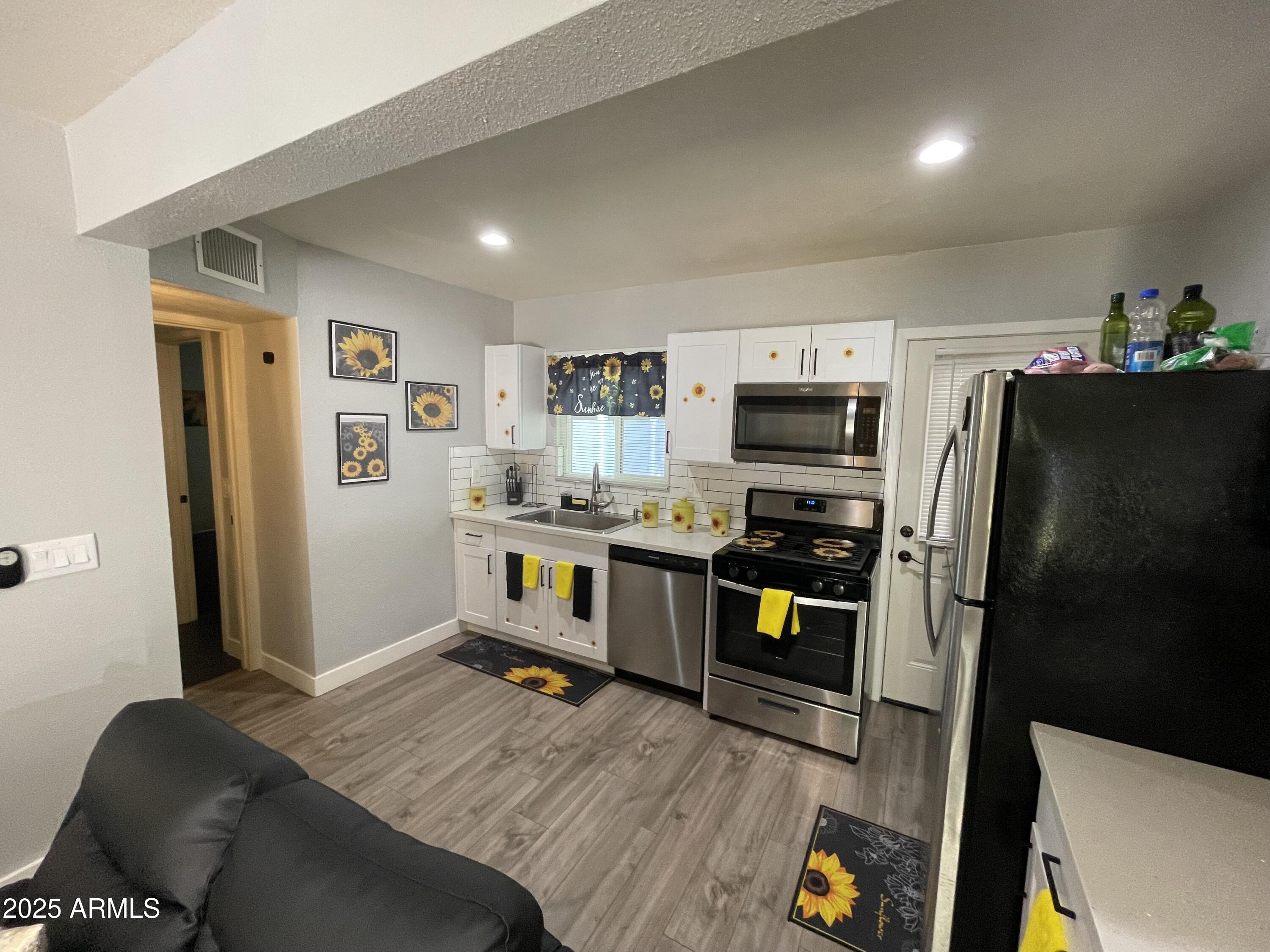 5963 West Ocotillo Road Glendale, AZ 85301 - Photo 2 of 12 a kitchen with stainless steel appliances a refrigerator and a stove top oven