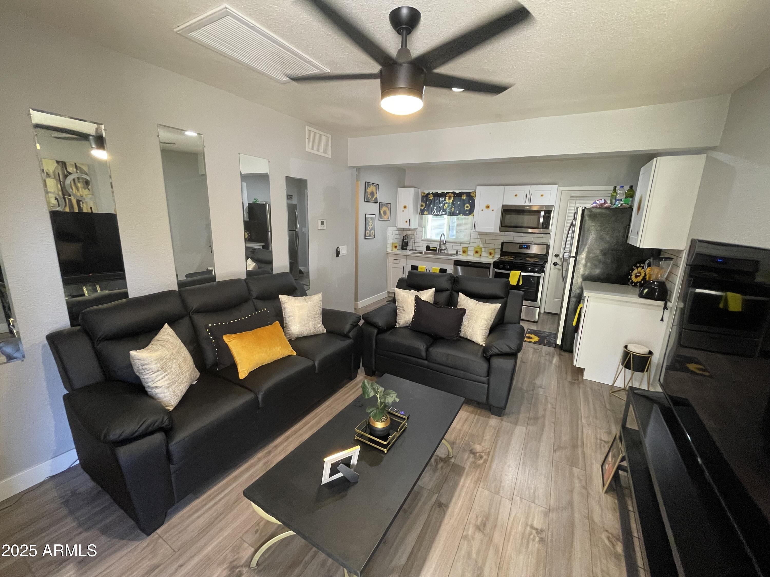 5963 West Ocotillo Road Glendale, AZ 85301 - Photo 3 of 12 a living room with furniture and a flat screen tv with kitchen view