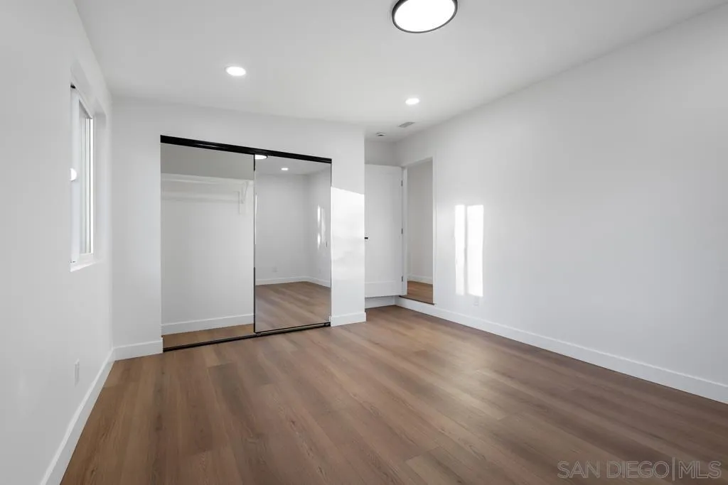 4516 Shade Road La Mesa, CA 91941 - Photo 21 of 33 an empty room with wooden floor and windows