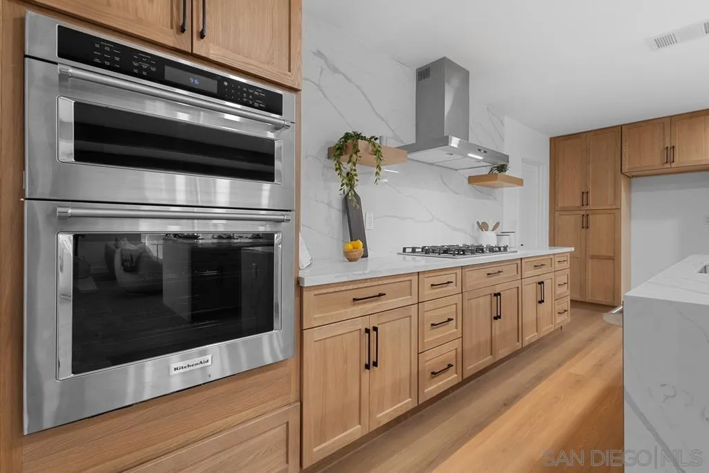 4516 Shade Road La Mesa, CA 91941 - Photo 6 of 33 a kitchen with stainless steel appliances granite countertop a stove microwave and cabinets
