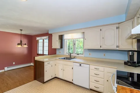 a kitchen with cabinets appliances a sink and a window