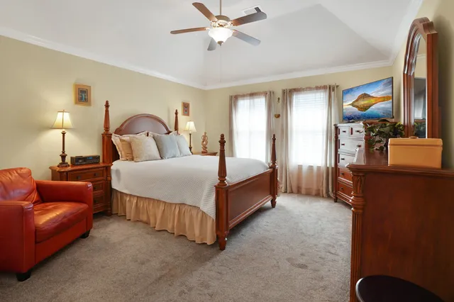 a bedroom with a bed couch and a chandelier