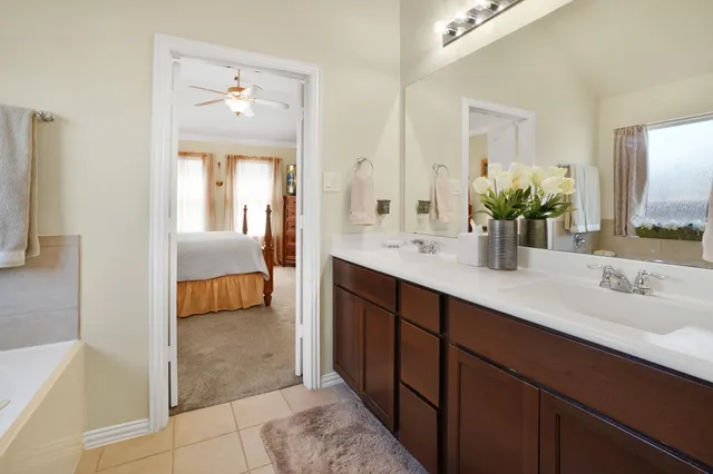 a en suite bathroom with a double vanity sink and a mirror