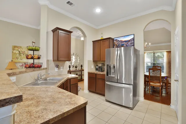 a kitchen with stainless steel appliances granite countertop a refrigerator and a sink