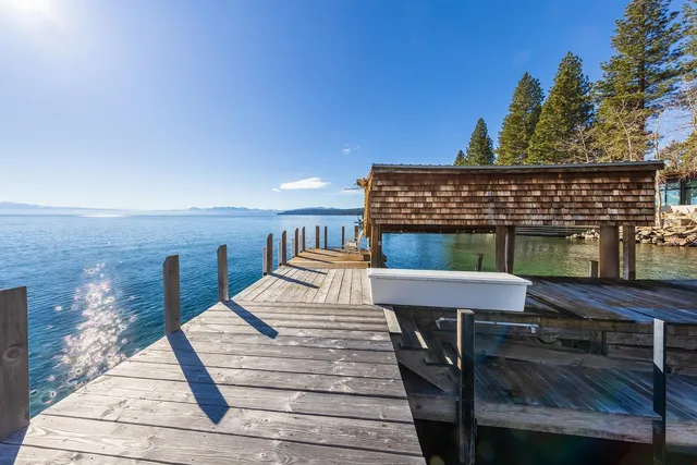 a roof deck with a dining table and chairs with wooden floor