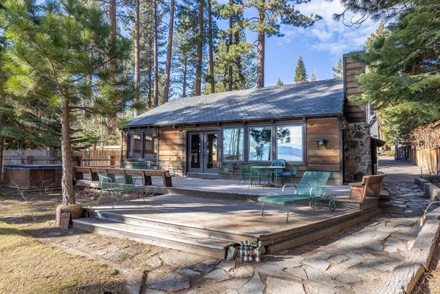 a view of a house with large windows and a table and chairs