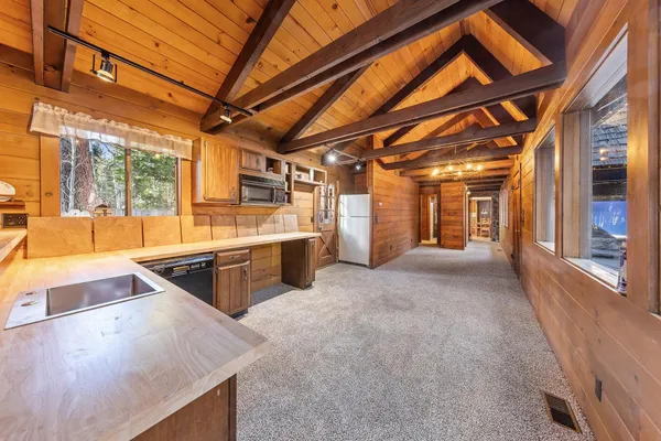 an empty room with wooden floor closet and windows