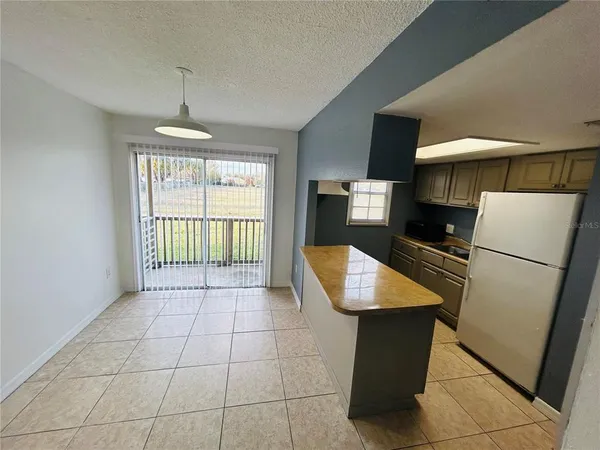 a kitchen with stainless steel appliances granite countertop a refrigerator a sink a stove top oven a counter space and cabinets
