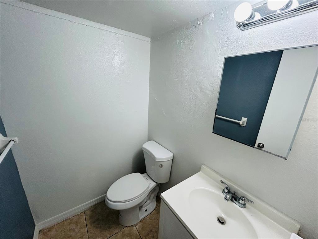 2775 L B McLeod Road, Unit B Orlando, FL 32805 - Photo 8 of 11 a bathroom with a sink a toilet and mirror