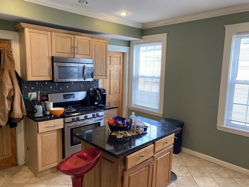 a kitchen with stainless steel appliances granite countertop a stove a sink dishwasher and a microwave