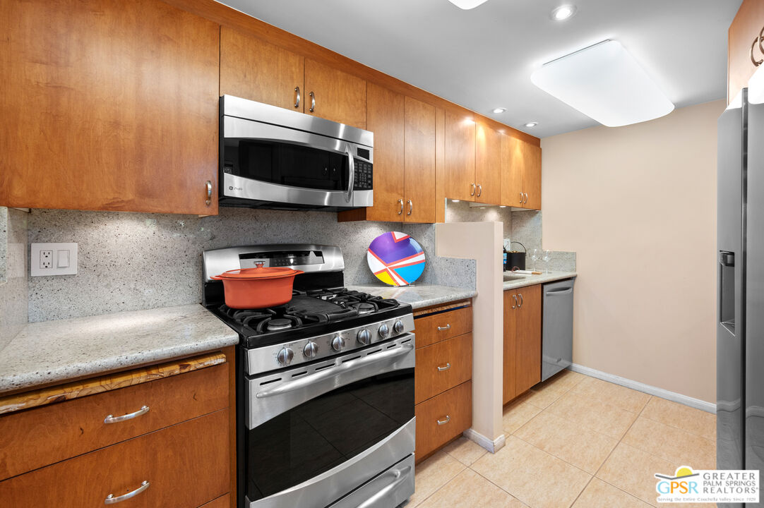 2033 Ramon Road, Unit 2C Palm Springs, CA 92264 - Photo 12 of 35 a kitchen with stainless steel appliances granite countertop a stove a sink and a microwave