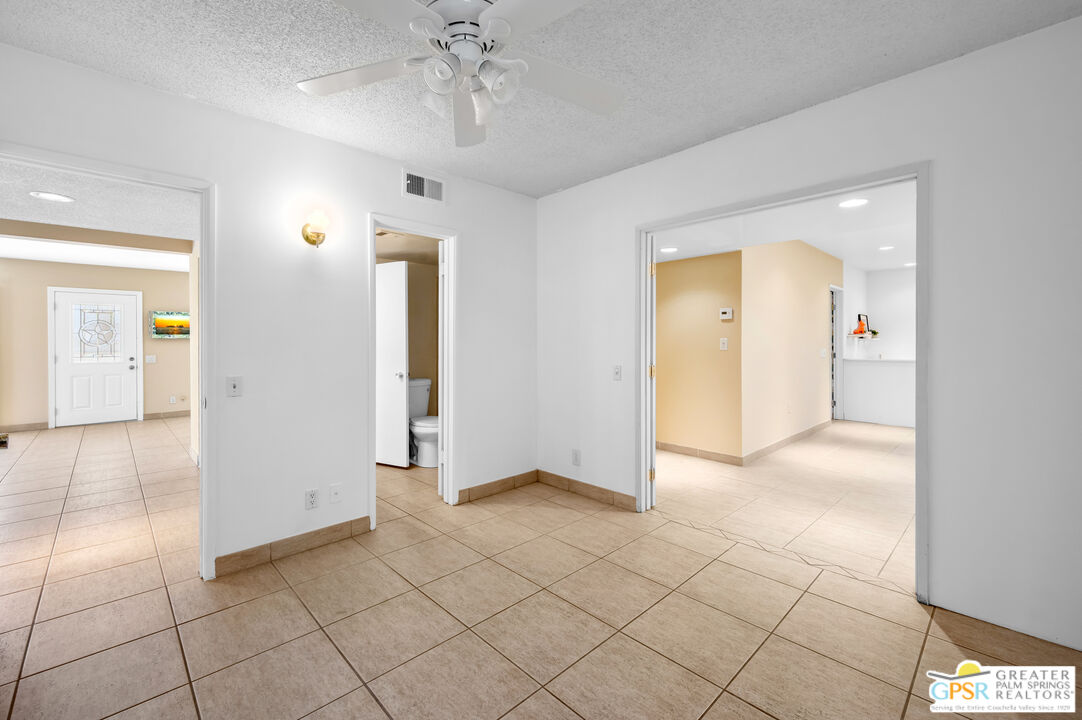 2033 Ramon Road, Unit 2C Palm Springs, CA 92264 - Photo 15 of 35 an empty room with kitchen and chandelier fan