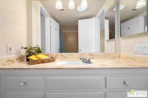 a bathroom with a granite countertop sink and a mirror