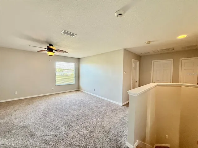 a view of a livingroom with a chandelier fan and a window