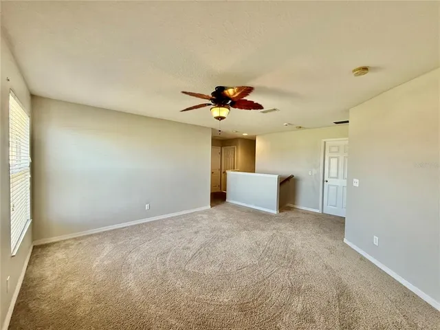 a view of a livingroom with a ceiling fan and window