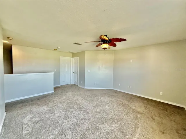a view of a big room with a chandelier fan