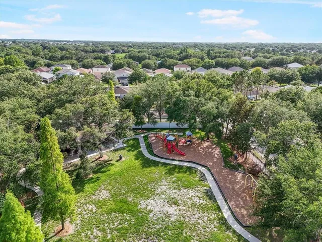 an aerial view of residential houses with outdoor space and trees