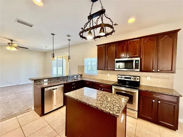 a kitchen with stainless steel appliances granite countertop a stove a sink dishwasher a microwave oven with granite countertops and cabinets