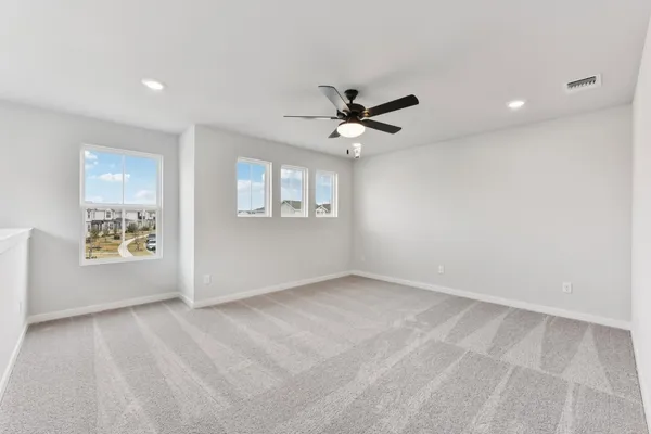 an empty room with windows and ceiling fan view