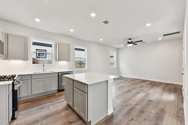 a kitchen with a sink cabinets and wooden floor