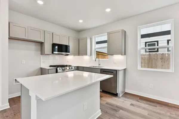 a kitchen with stainless steel appliances granite countertop a sink a stove and microwave