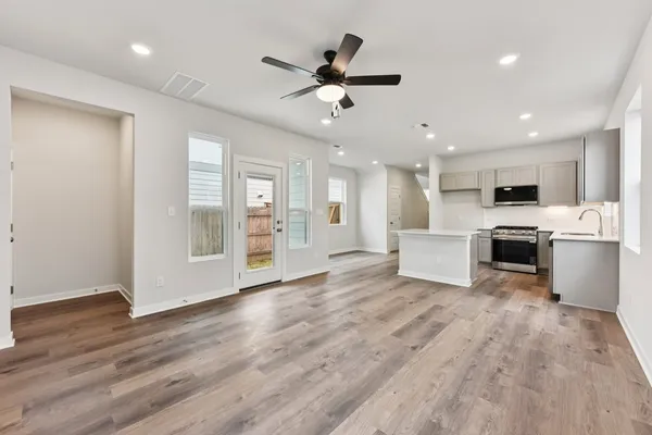 a view of a kitchen with wooden floor and a ceiling fan