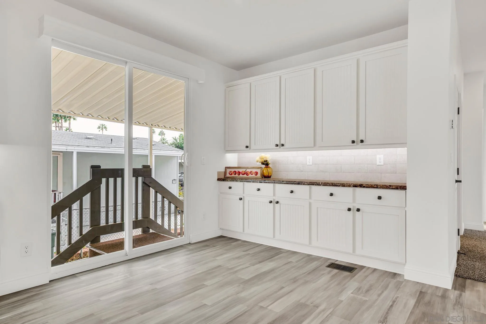 2515 Sweetwater Road, Unit 76 Spring Valley, CA 91977 - Photo 11 of 31 a hallway with white cabinets and wooden floor