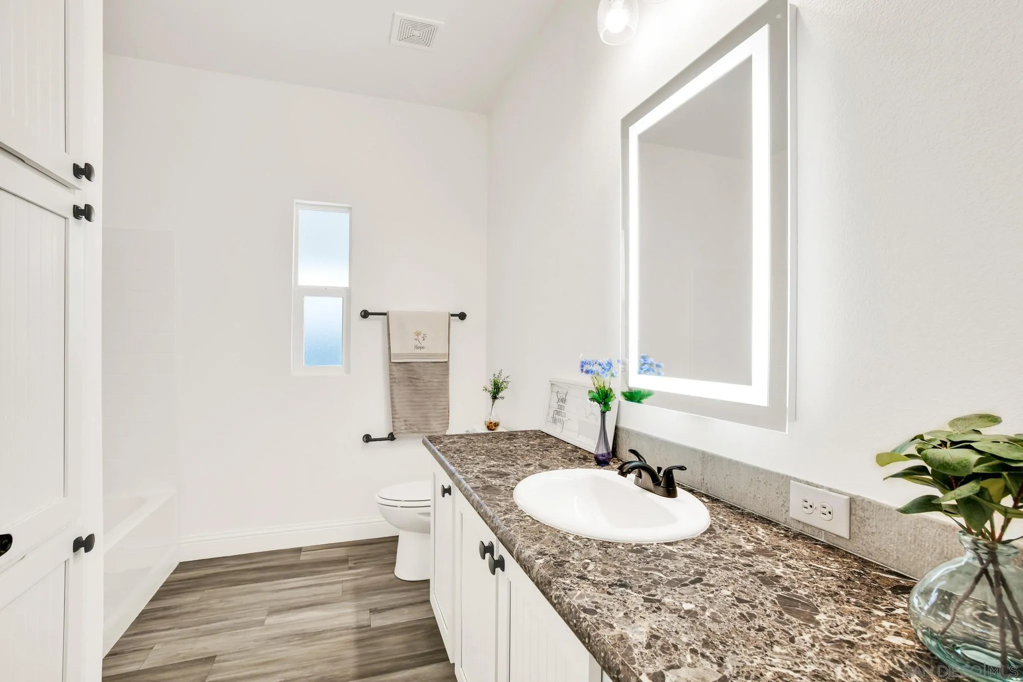 2515 Sweetwater Road, Unit 76 Spring Valley, CA 91977 - Photo 20 of 31 a bathroom with a granite countertop sink and a mirror