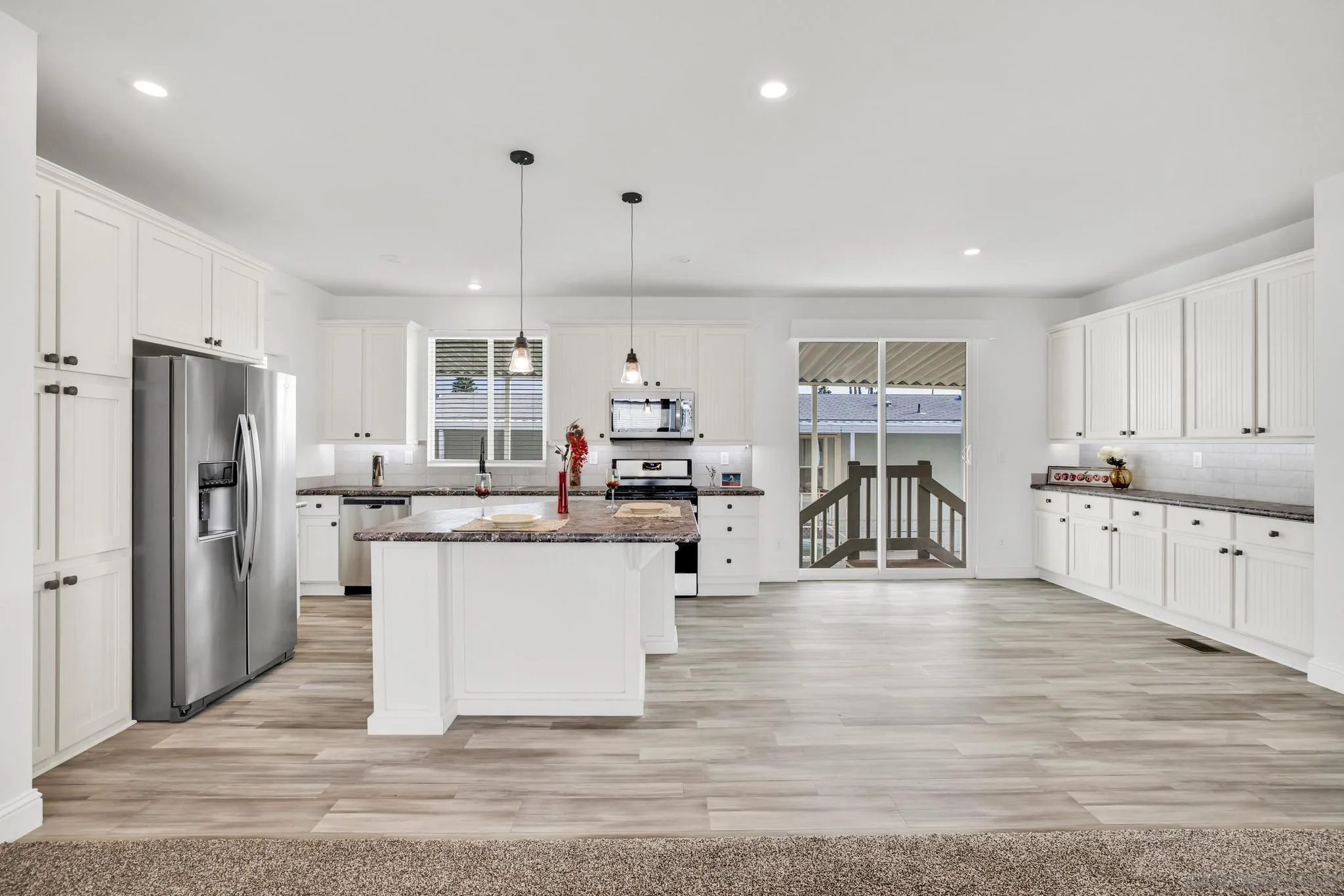 2515 Sweetwater Road, Unit 76 Spring Valley, CA 91977 - Photo 7 of 31 a kitchen with stainless steel appliances kitchen island granite countertop a refrigerator and a sink