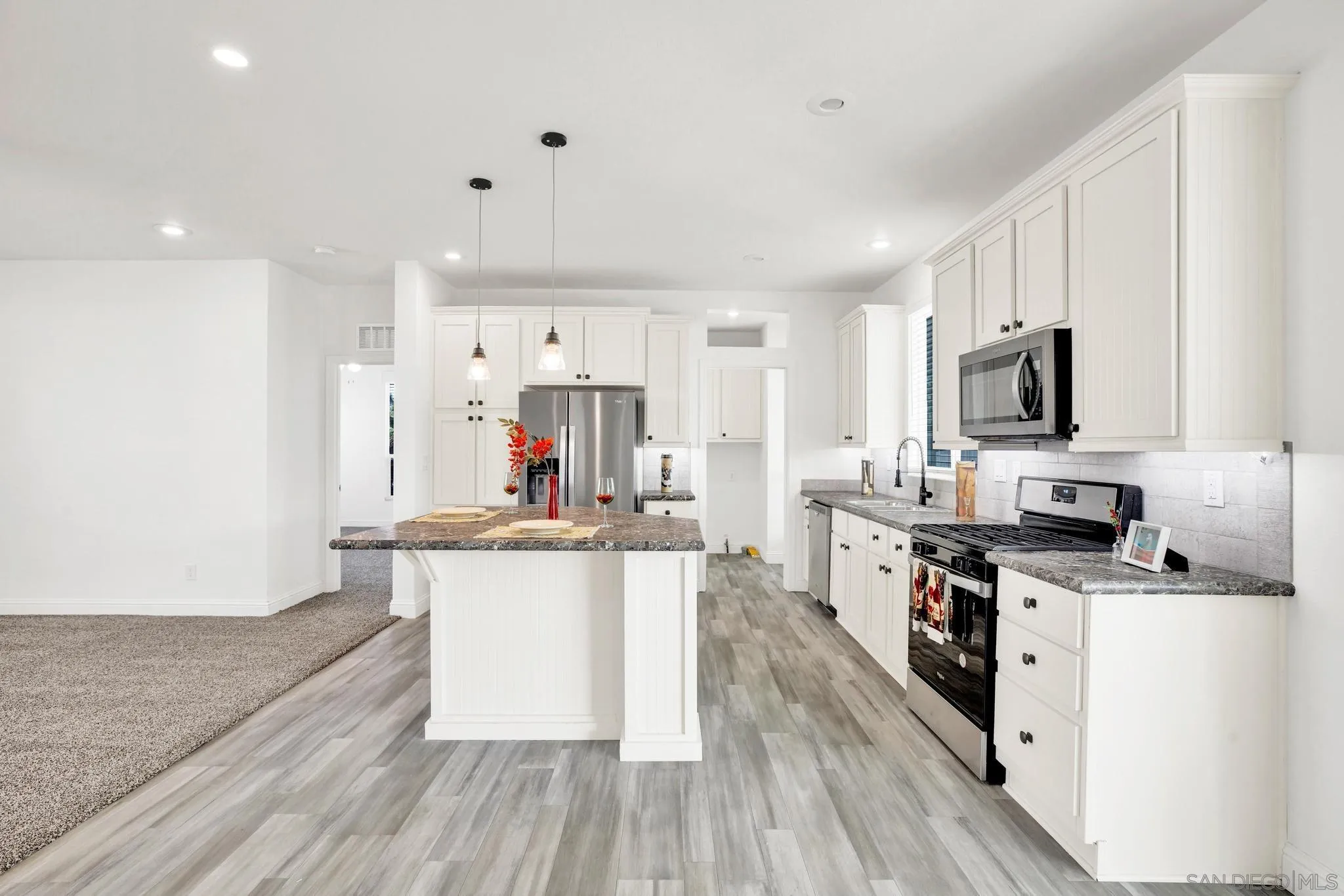 2515 Sweetwater Road, Unit 76 Spring Valley, CA 91977 - Photo 10 of 31 a kitchen with stainless steel appliances a stove top oven a sink dishwasher and a refrigerator