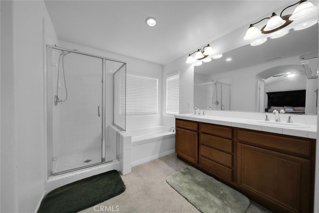 28440 Ware Street Murrieta, CA 92563 - Photo 50 of 72 a bathroom with a double vanity sink a mirror and a bathtub