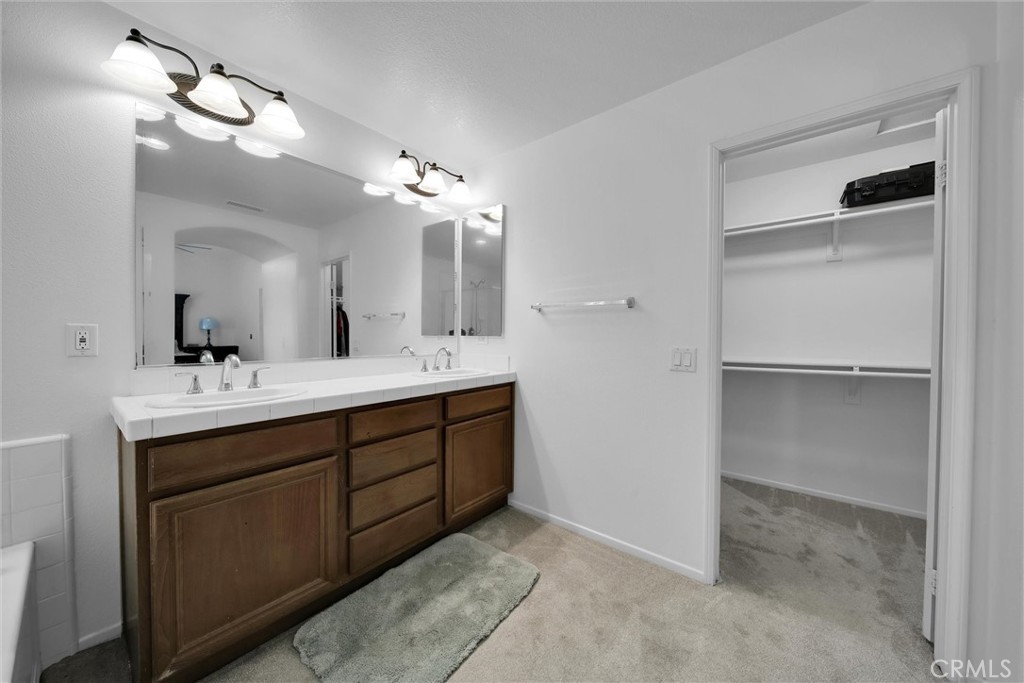 28440 Ware Street Murrieta, CA 92563 - Photo 53 of 72 a bathroom with a double vanity sink a mirror and a shower