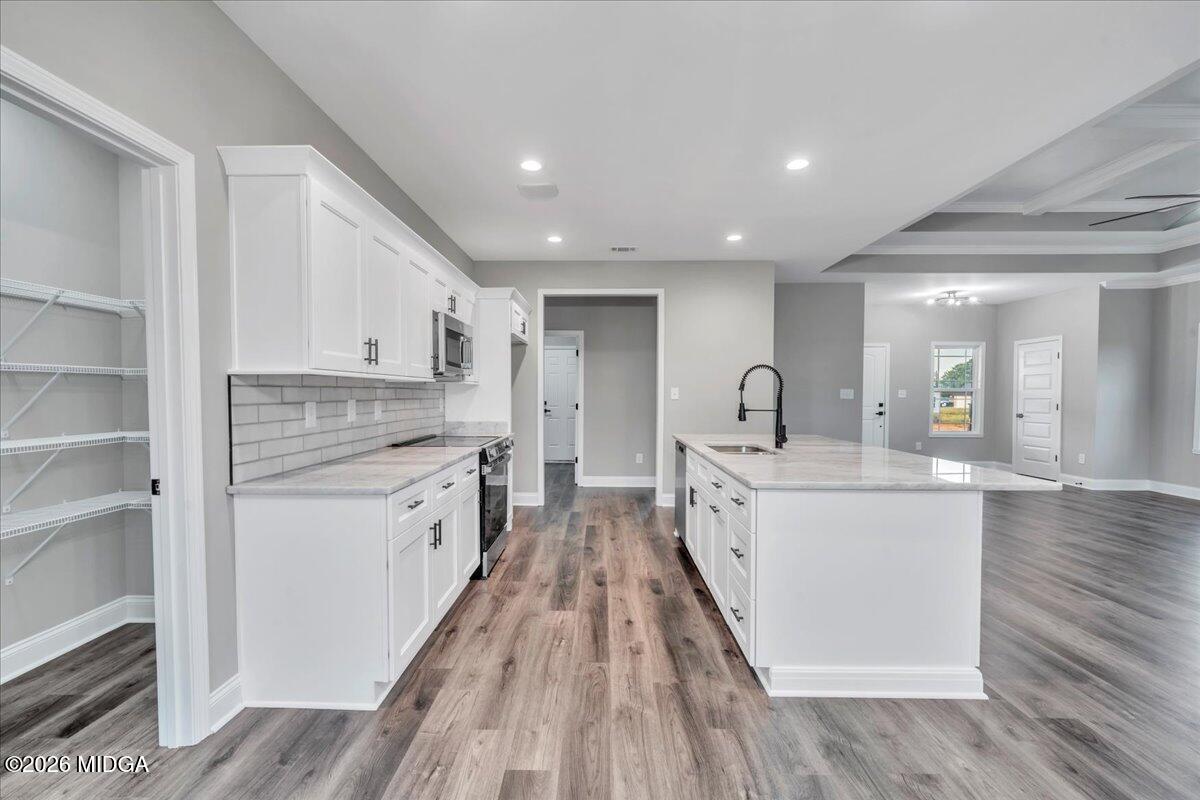 208 Eric Court Byron, GA 31008 - Photo 21 of 57 a large kitchen with kitchen island white cabinets and stainless steel appliances