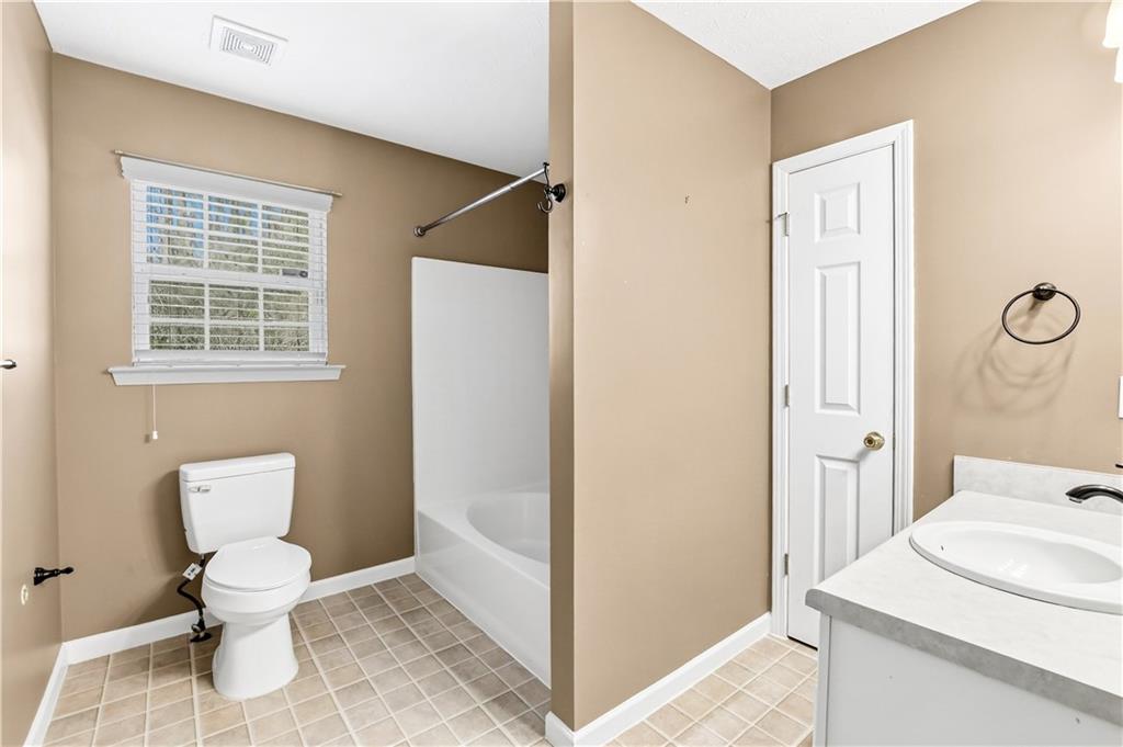 5976 Bowers Road Stone Mountain, GA 30087 - Photo 19 of 29 a bathroom with a toilet sink and a mirror