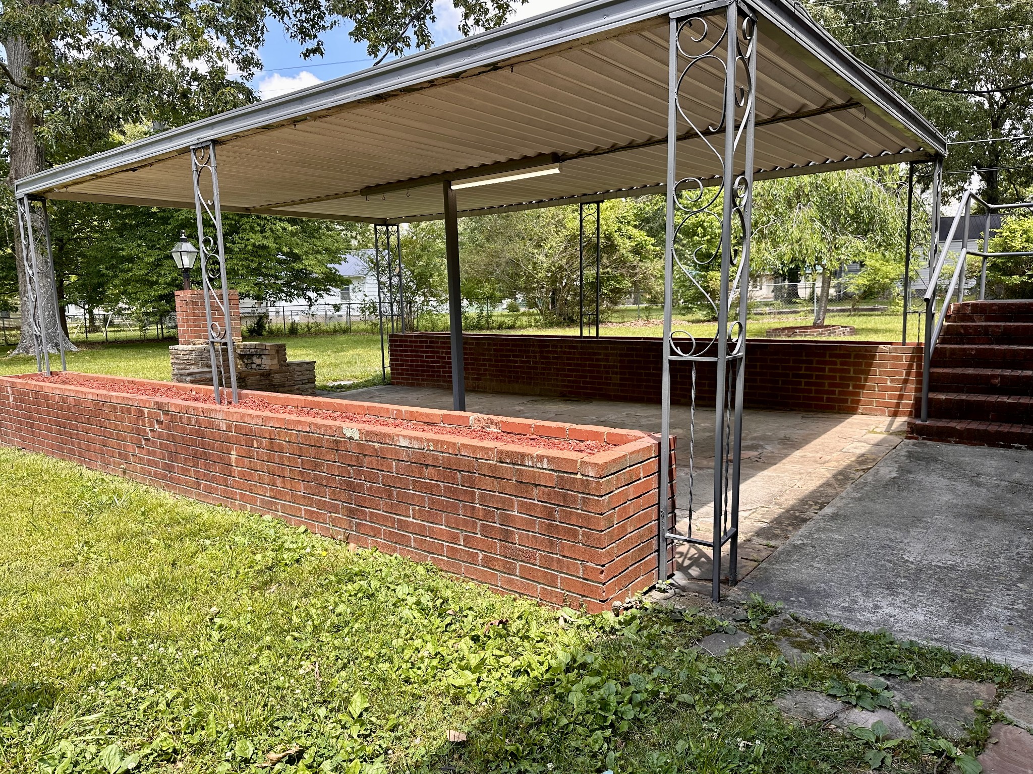 912 Hills Chapel Road Manchester, TN 37355 - Photo 23 of 23 a view of a patio with a table and chairs under an umbrella