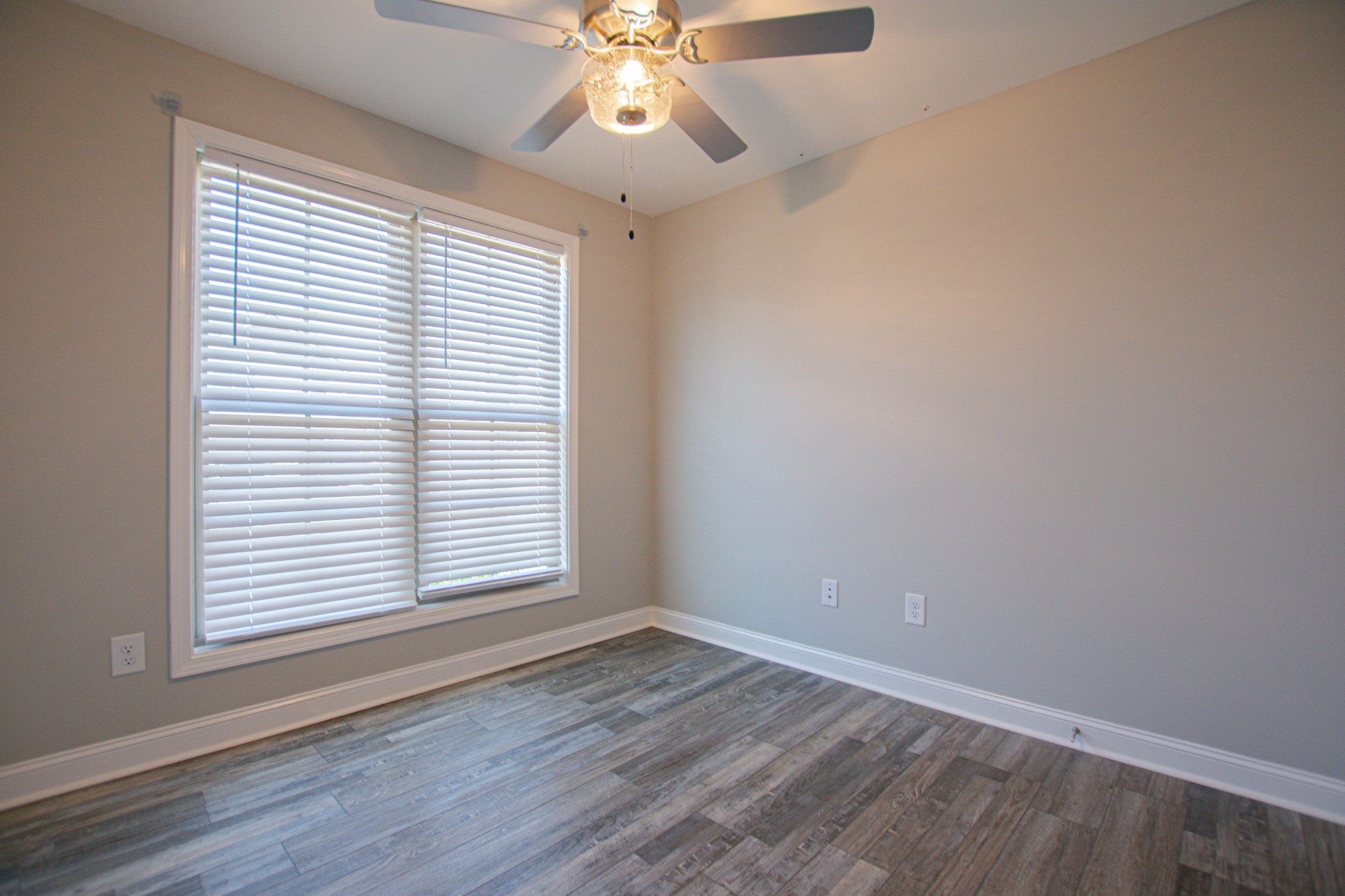 104 Schroer Road Clarksville, TN 37042 - Photo 12 of 25 an empty room with wooden floor chandelier fan and windows